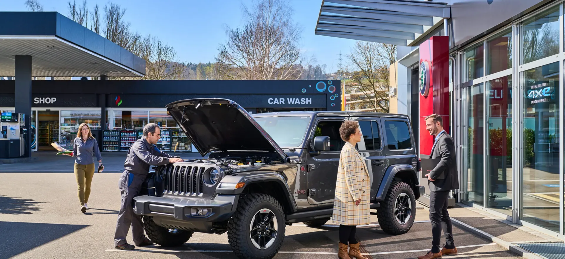 A Fiat showroom consultant engages warmly with two customers, perfectly embodying Garage Bosshardt's philosophy of personal, relationship-driven car buying.
