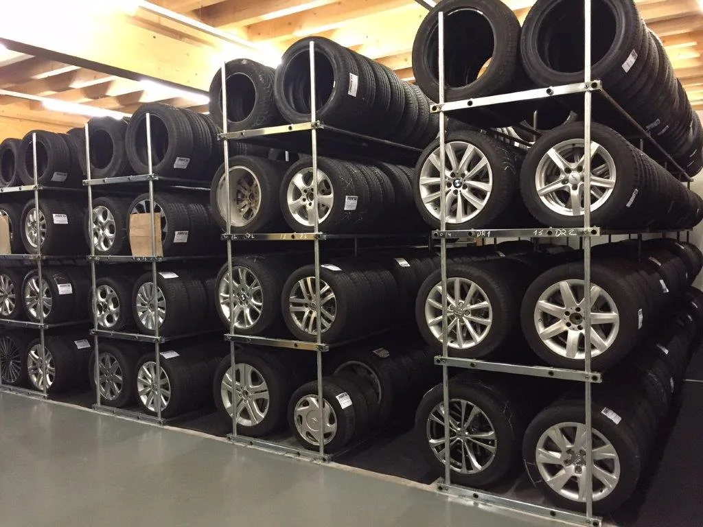 Wall of neatly organised customer wheels and tires stored on metal racks in the tire hotel.