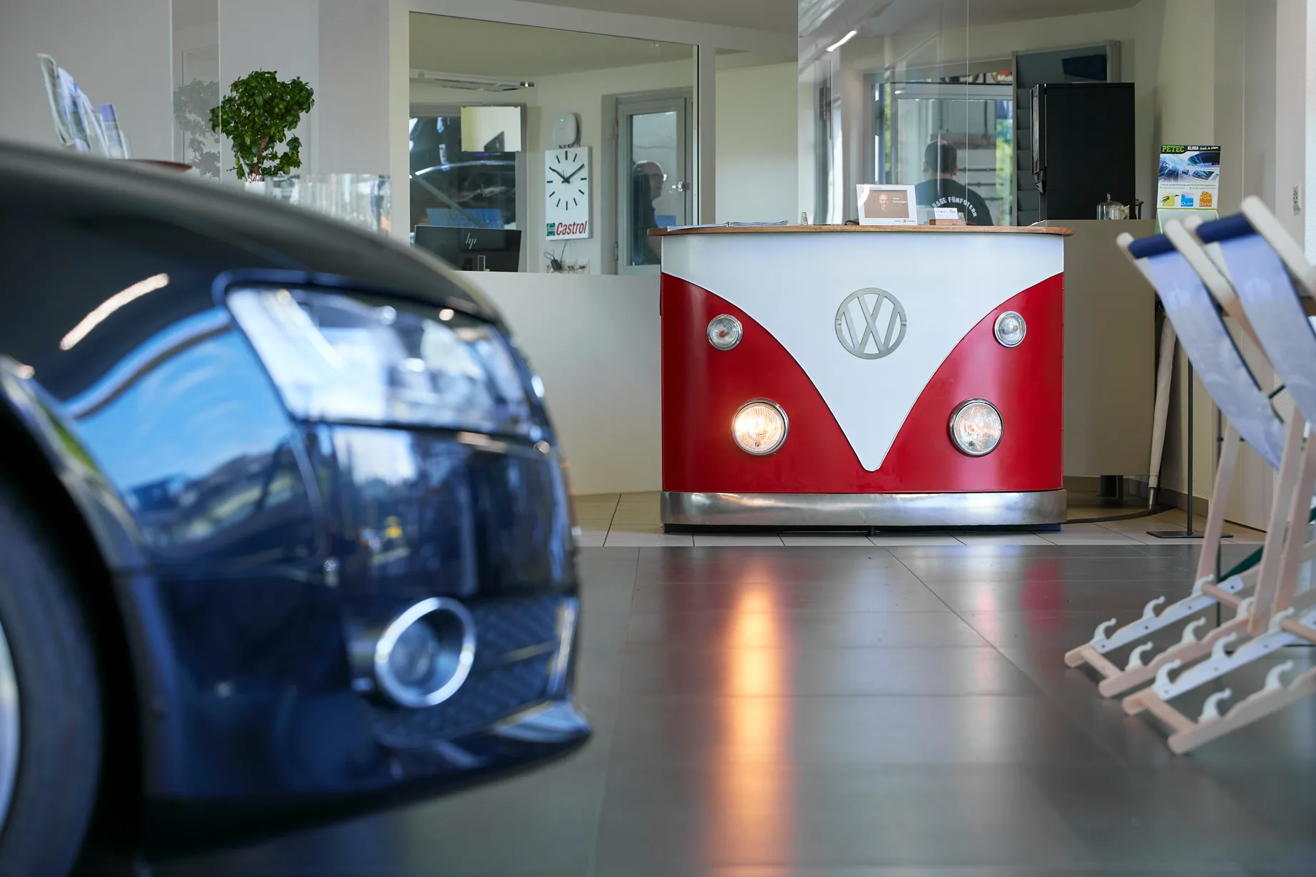 Charming VW Bus-themed reception desk in the showroom interior with reflective tiled floor.